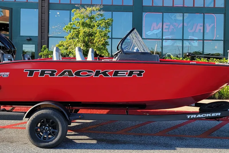 The Image of Red 2027 Tracker Pro Guide V-175 Combo boat on trailer, parked outdoors. - 0