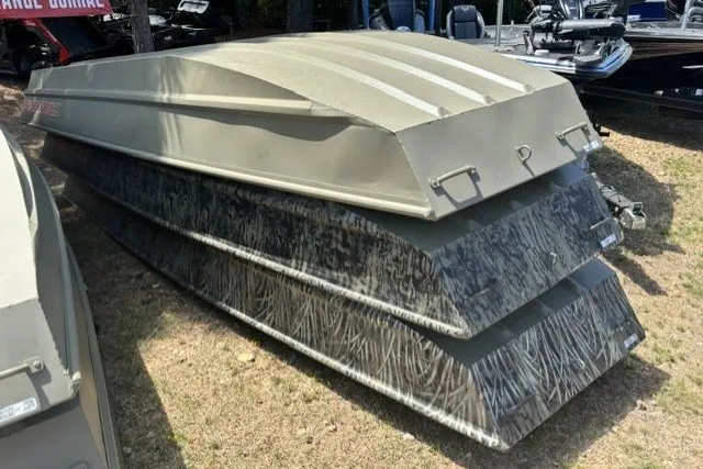 The Image of 2027 Tracker Grizzly 15 Jon boats stacked on grass, showcasing durable design and camouflage pattern. - 0