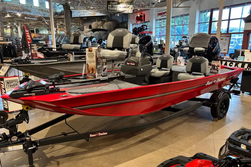 The Image of 2027 Tracker Bass Tracker Classic XL boat displayed in showroom, featuring red exterior and seating. - 0