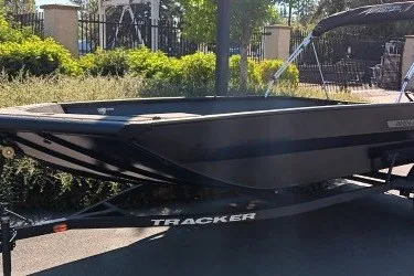 The Image of 2027 Tracker Grizzly 1756 T Marsh boat on trailer, outdoors in sunlight. - 0