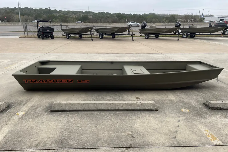 The Image of 2027 Tracker Grizzly 15 Jon boat displayed outdoors on concrete surface. - 0