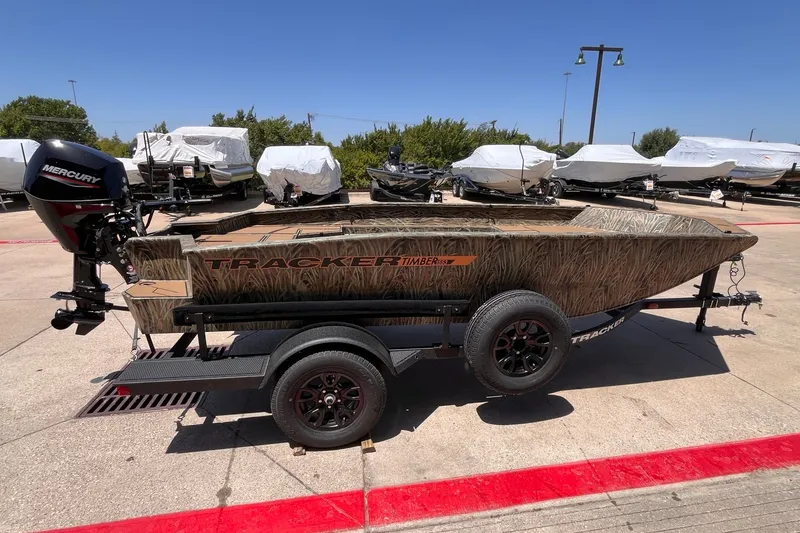 The Image of 2027 Tracker Grizzly 1553 Timber boat on trailer, camo design, with Mercury outboard motor. - 0