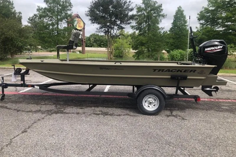 The Image of 2027 Tracker Grizzly 1654 T Sportsman boat on trailer, parked outdoors. - 0