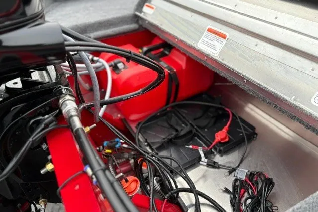 Slide: The Image of Interior view of 2027 Tracker Super Guide V-16 SC boat with wiring and red fuel tank. - 23
