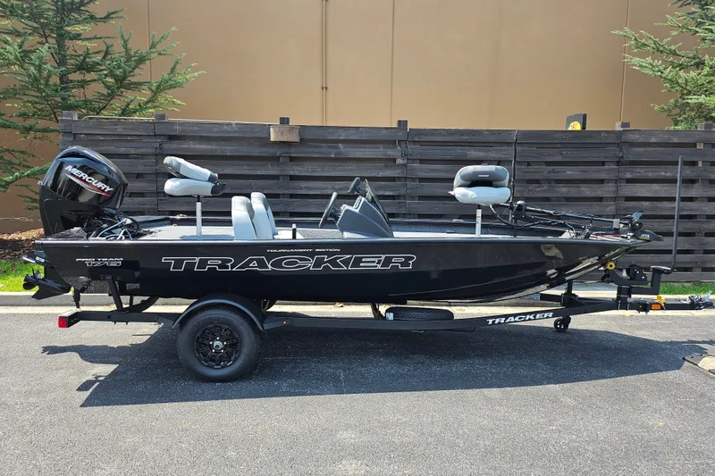 The Image of 2027 Tracker Pro Team 175 boat on trailer, parked outdoors, featuring Mercury engine. - 0