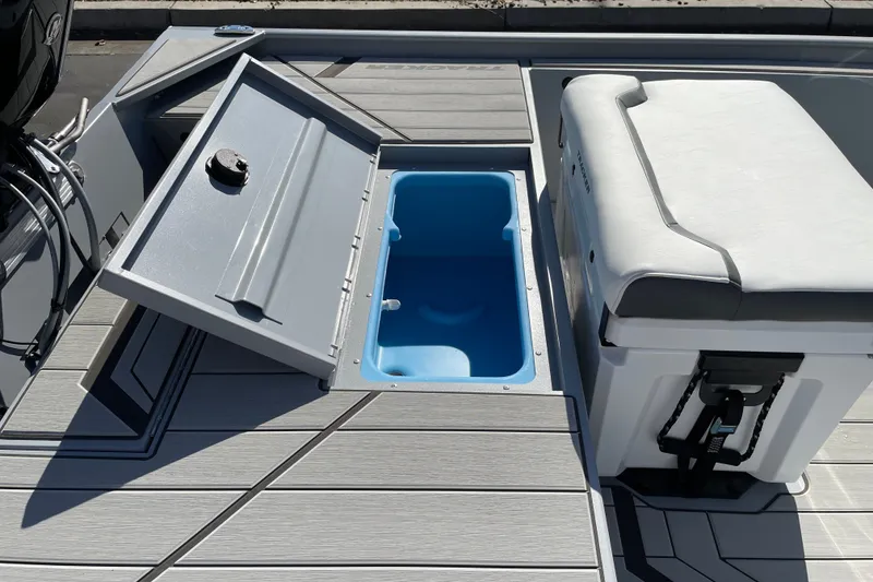 Slide: The Image of 2027 Tracker Bass Tracker Classic CC boat deck with open storage compartment and cushioned seat. - 15
