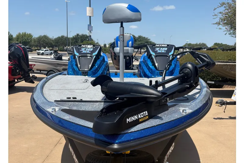 Slide: The Image of 2027 Nitro Z18 XL boat with Minn Kota trolling motor, parked outdoors under clear skies. - 2