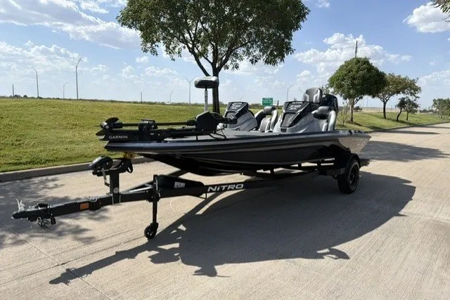Slide: The Image of 2027 Nitro Z18 XL Pro boat on trailer, parked on sunny road with trees. - 2