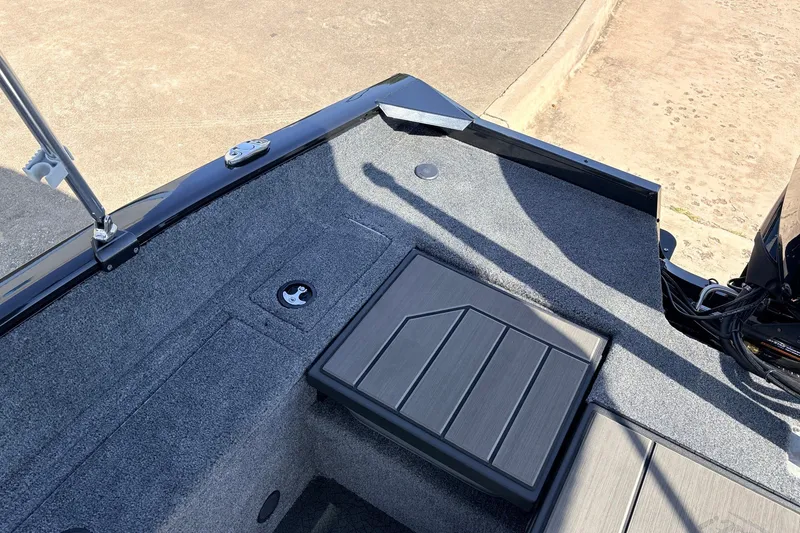 Slide: The Image of 2027 Tracker Pro Guide V-175 Combo boat interior with carpeted deck and storage compartment. - 50