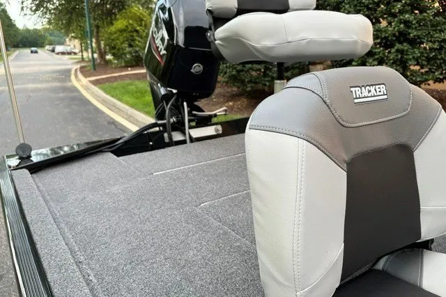 Slide: The Image of 2027 Tracker Bass Tracker Classic XL boat with cushioned seating and motor, parked outdoors. - 13