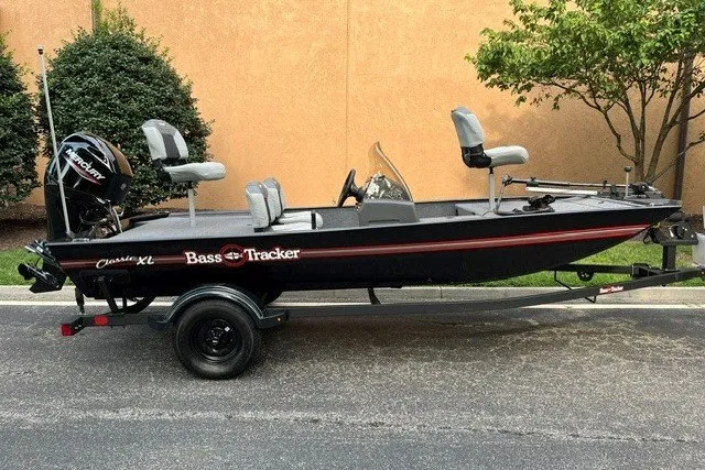 The Image of 2027 Tracker Bass Tracker Classic XL fishing boat on trailer, parked outdoors. - 0