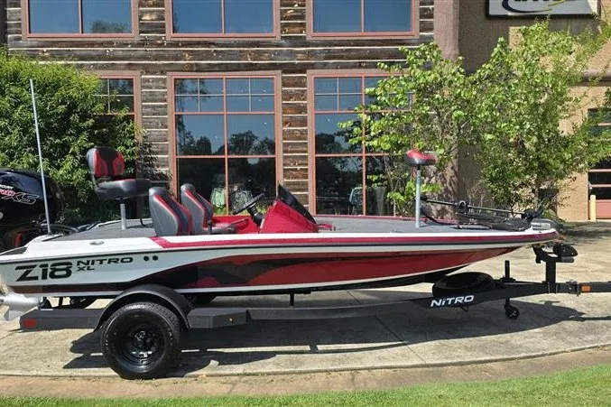 Slide: The Image of 2027 Nitro Z18 XL boat parked outdoors, featuring sleek design and vibrant red accents. - 1