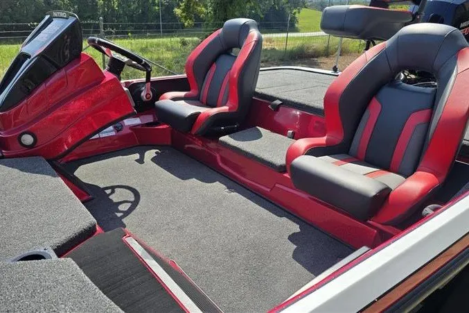 Slide: The Image of 2027 Nitro Z18 XL boat interior with red and gray seating, steering wheel, and spacious deck. - 10