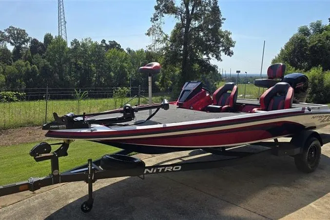 Slide: The Image of 2027 Nitro Z18 XL boat with red and black design, parked outdoors on a sunny day. - 5