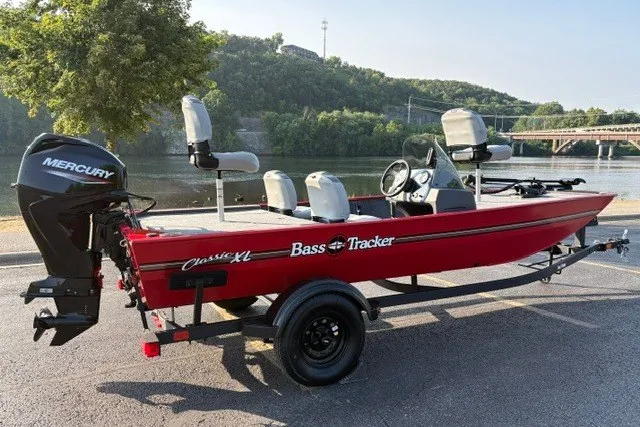 The Image of 2027 Tracker Bass Tracker Classic XL boat with Mercury engine, parked by a scenic river. - 2