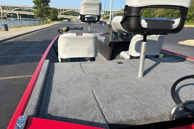 Slide: The Image of 2027 Tracker Bass Tracker Classic XL boat with seating, parked near a river. - 20