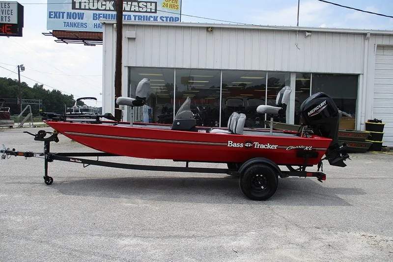 The Image of 2027 Tracker Bass Tracker Classic XL boat in red, parked outside a dealership. - 1