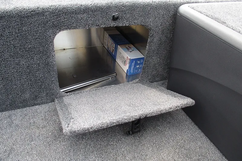 Slide: The Image of Storage compartment in 2027 Tracker Bass Tracker Classic XL boat, featuring carpeted interior. - 16