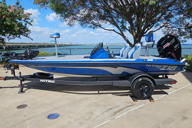 The Image of 2027 Nitro Z18 XL Pro boat on trailer by waterfront, under clear sky. - 0