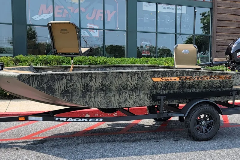 The Image of 2027 Tracker Grizzly 1553 Timber boat on trailer, parked outside a showroom. - 0