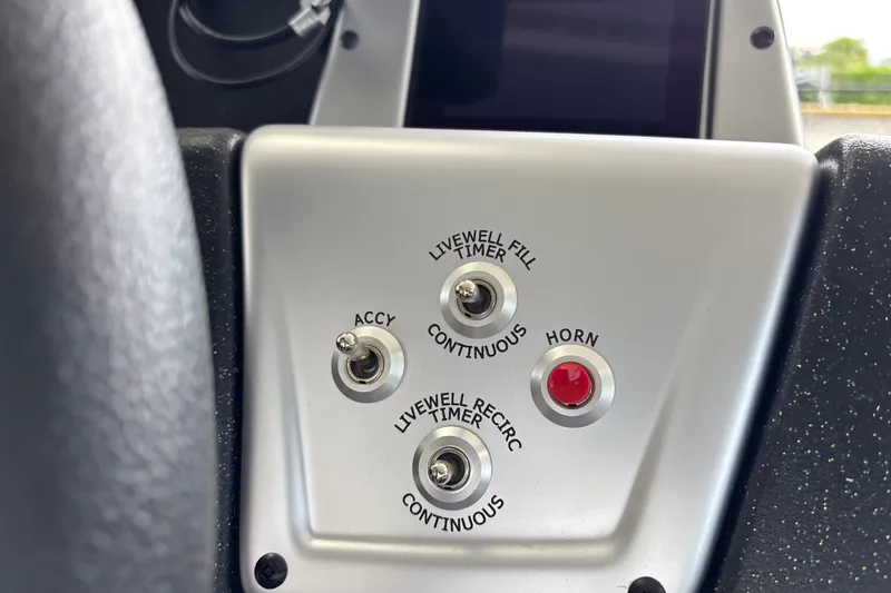 Slide: The Image of Control panel of 2027 Tracker Pro Team 175 boat with switches and horn button. - 13