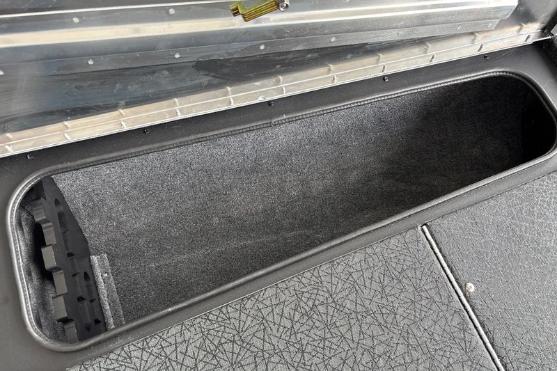 Slide: The Image of 2027 Tracker Pro Team 175 boat storage compartment with textured interior and secure latch. - 29