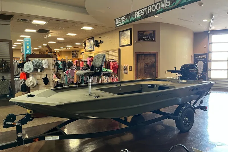 The Image of 2027 Tracker Grizzly 1654 T Sportsman boat displayed in an indoor showroom setting. - 0