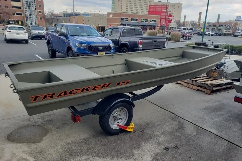 The Image of 2027 Tracker Grizzly 15 Jon boat on trailer in urban parking lot. - 0