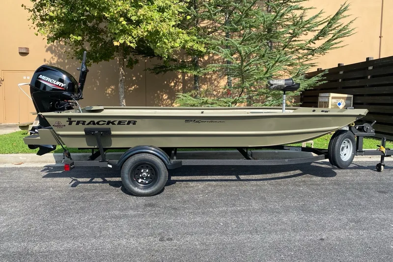 The Image of 2027 Tracker Grizzly 1654 T Sportsman boat on trailer, parked outdoors. - 0