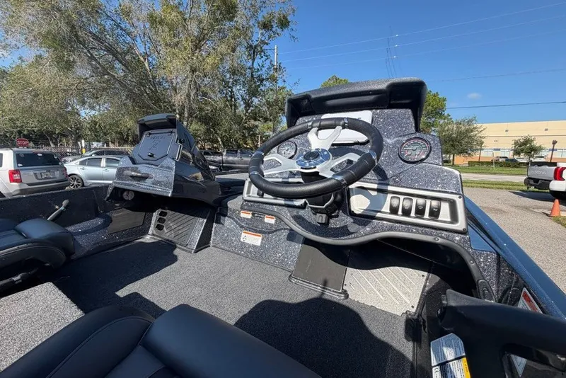 Slide: The Image of 2027 Nitro Z18 XL boat dashboard with steering wheel and control panel in a parking lot. - 8