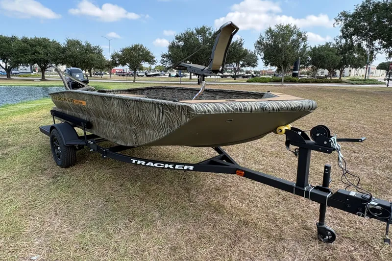 The Image of 2027 Tracker Grizzly 1553 Timber boat on trailer, parked on grass near a pond. - 0