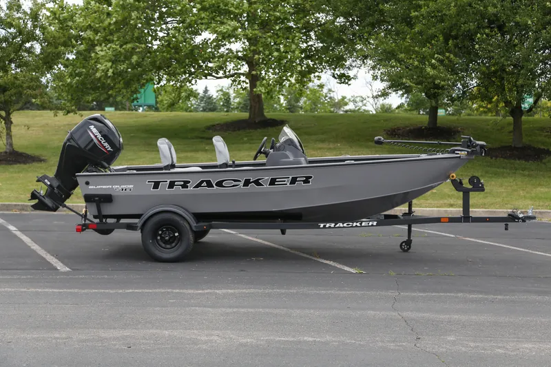 The Image of 2027 Tracker Super Guide V-16 SC boat on trailer, parked outdoors. - 0
