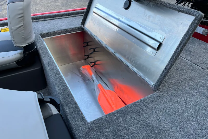 Slide: The Image of Storage compartment in 2027 Tracker Bass Tracker Classic XL boat with orange paddles. - 11
