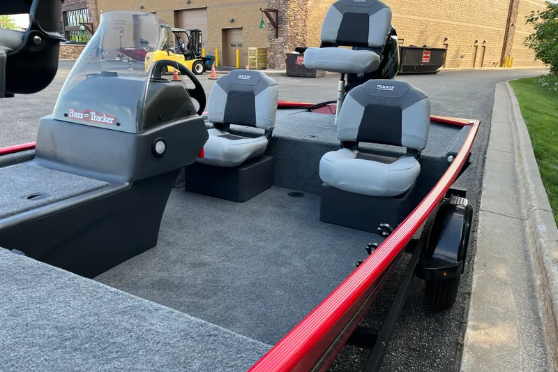 Slide: The Image of 2027 Tracker Bass Tracker Classic XL boat with dual seats and red trim parked outdoors. - 9