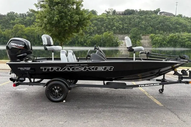 The Image of 2027 Tracker Pro Team 175 boat with Mercury engine, parked near a scenic lake. - 0
