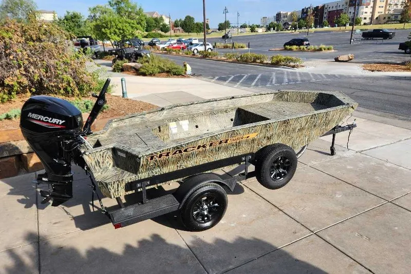 The Image of 2027 Tracker Grizzly 1553 Timber boat on trailer, parked outdoors with Mercury outboard motor. - 0