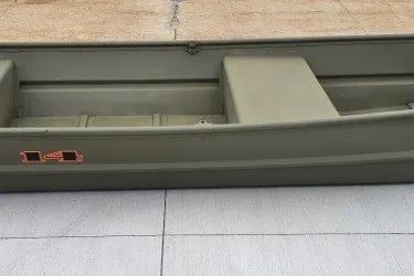 The Image of 2027 Tracker Grizzly 14 Jon boat, olive green, side view on concrete surface. - 0