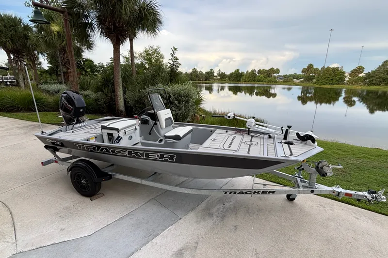The Image of 2027 Tracker Bass Tracker Classic CC boat on trailer by a scenic lake. - 0