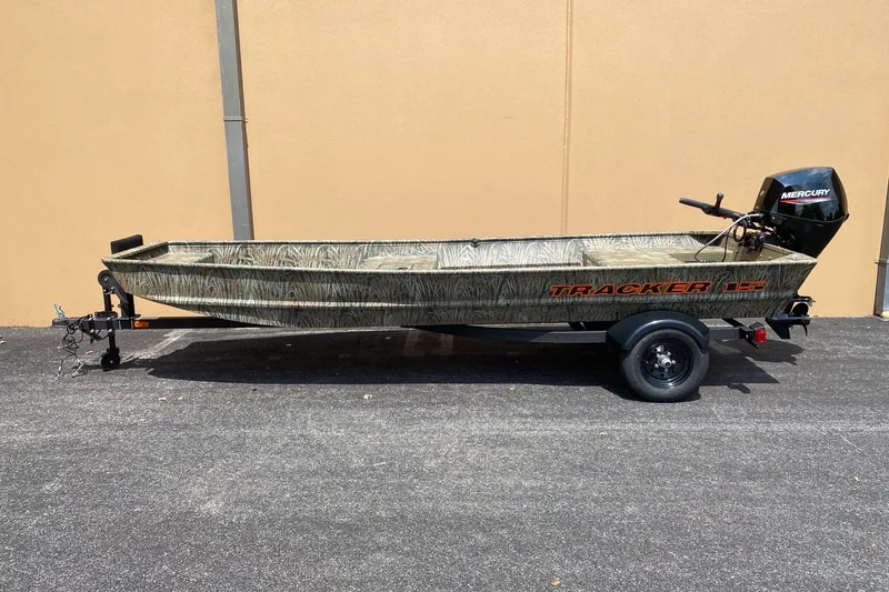 The Image of 2027 Tracker Grizzly 15 Jon boat with Mercury motor on trailer, parked outdoors. - 0
