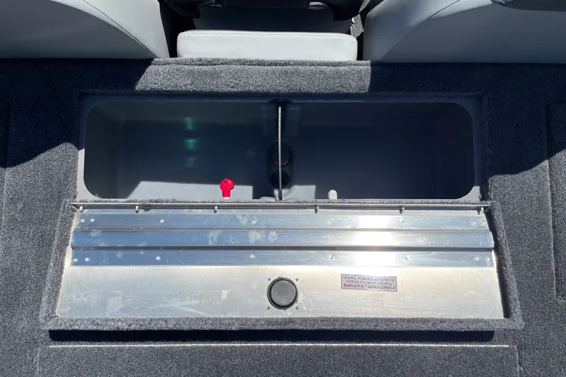Slide: The Image of Open storage compartment in 2027 Tracker Pro Team 175 boat, featuring a metallic lid and carpeted interior. - 14