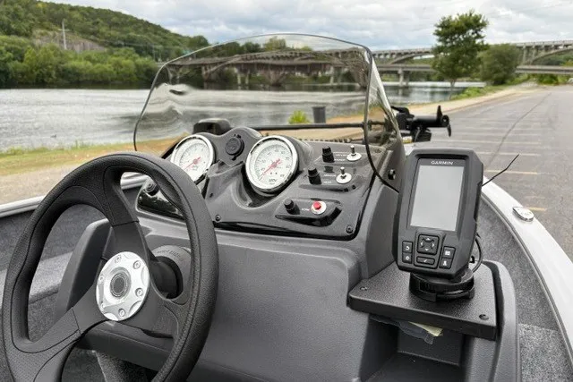 Slide: The Image of Dashboard of a 2027 Tracker Super Guide V-16 SC boat with gauges and GPS near a river. - 22