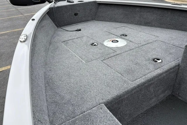 Slide: The Image of 2027 Tracker Super Guide V-16 SC boat interior with gray carpeted deck and storage compartments. - 21