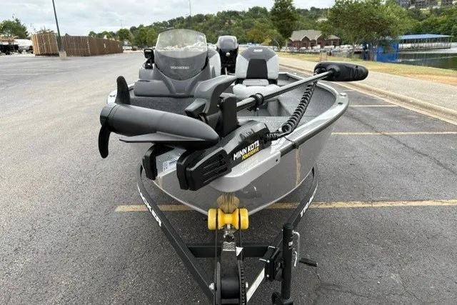 Slide: The Image of 2027 Tracker Super Guide V-16 SC fishing boat with Minn Kota trolling motor in a parking lot. - 15
