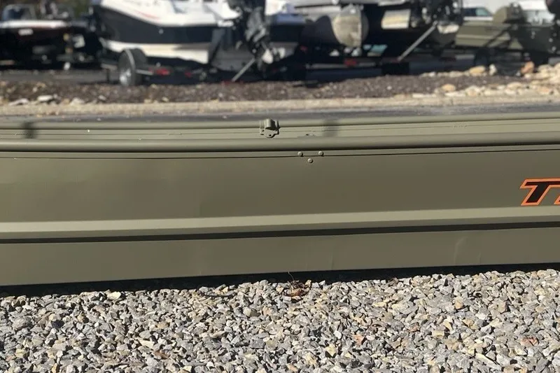 The Image of 2027 Tracker Grizzly 15 Jon boat on gravel, with trailers in the background. - 0