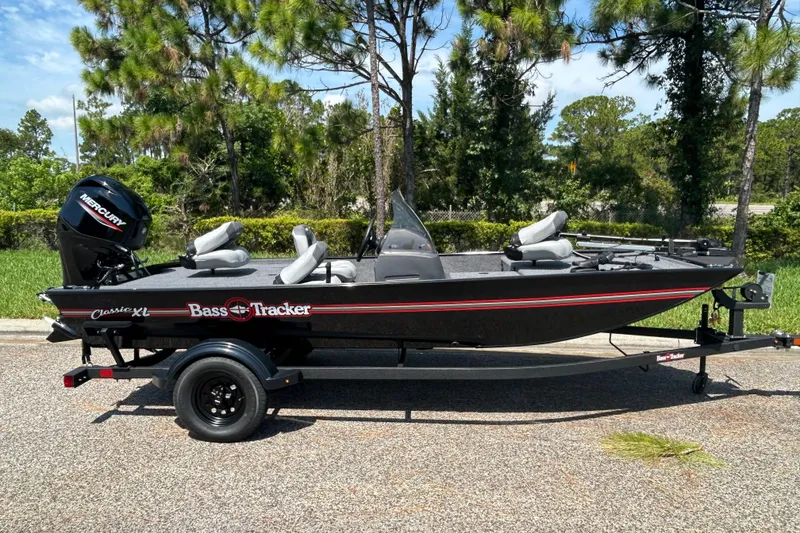 The Image of 2027 Tracker Bass Tracker Classic XL boat on trailer, parked outdoors. - 0