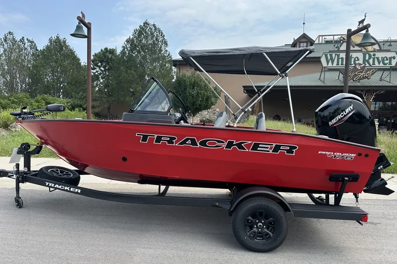 The Image of 2027 Tracker Pro Guide V-175 Combo boat on trailer, red exterior, parked outdoors. - 0