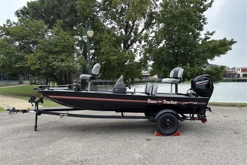 The Image of 2027 Tracker Bass Tracker Classic XL boat on trailer by a lake. - 0