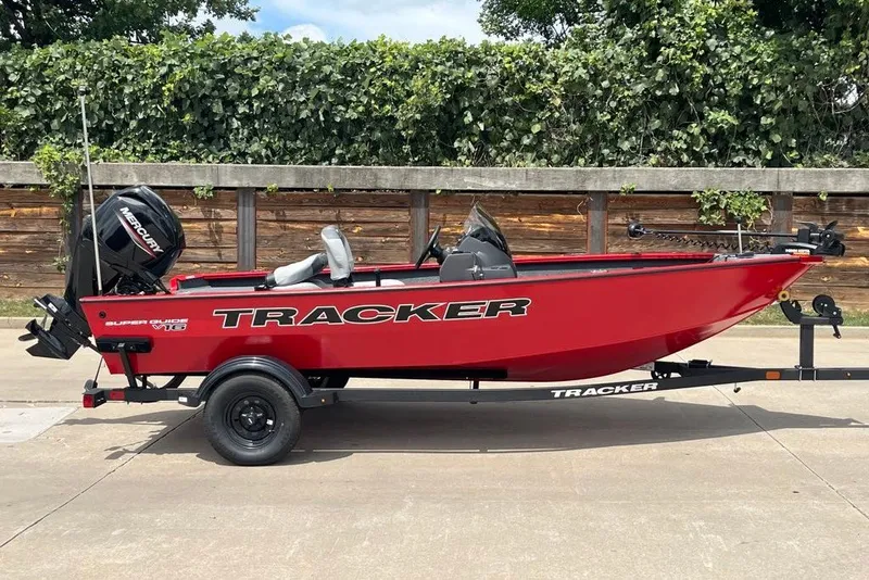 The Image of 2027 Tracker Super Guide V-16 SC boat on trailer, red exterior, parked outdoors. - 0
