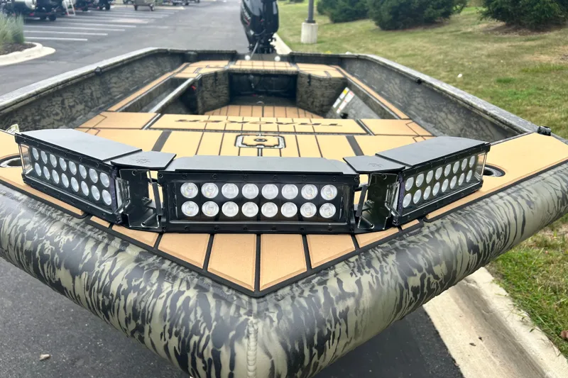 Slide: The Image of 2027 Tracker Grizzly 1553 Timber boat with LED lights, camo design, parked outdoors. - 15