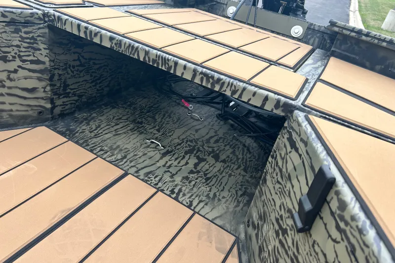 Slide: The Image of Interior view of 2027 Tracker Grizzly 1553 Timber boat with camouflage design and storage space. - 14
